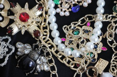 Zümrüt değerli taşlı klasik broşürler. Farklı renklerde cam ve metal broşlar. Renkli ve moda broşları. Lüks bir geçmişi var. Seçici odak