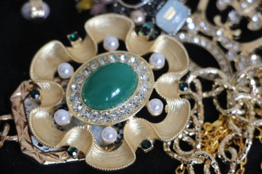 Zümrüt değerli taşlı klasik broşürler. Farklı renklerde cam ve metal broşlar. Renkli ve moda broşları. Lüks bir geçmişi var. Seçici odak