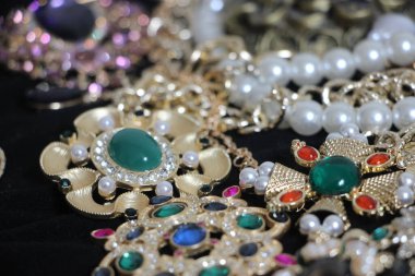 Zümrüt değerli taşlı klasik broşürler. Farklı renklerde cam ve metal broşlar. Renkli ve moda broşları. Lüks bir geçmişi var. Seçici odak