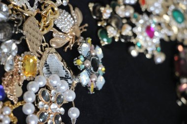 Zümrüt değerli taşlı klasik broşürler. Farklı renklerde cam ve metal broşlar. Renkli ve moda broşları. Lüks bir geçmişi var. Seçici odak