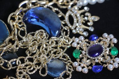 Zümrüt değerli taşlı klasik broşürler. Farklı renklerde cam ve metal broşlar. Renkli ve moda broşları. Lüks bir geçmişi var. Seçici odak