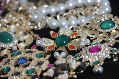 Zümrüt değerli taşlı klasik broşürler. Farklı renklerde cam ve metal broşlar. Renkli ve moda broşları. Lüks bir geçmişi var. Seçici odak