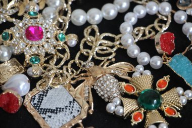 Zümrüt değerli taşlı klasik broşürler. Farklı renklerde cam ve metal broşlar. Renkli ve moda broşları. Lüks bir geçmişi var. Seçici odak