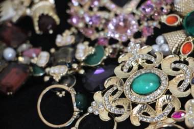 Zümrüt değerli taşlı klasik broşürler. Farklı renklerde cam ve metal broşlar. Renkli ve moda broşları. Lüks bir geçmişi var. Seçici odak