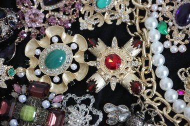 Zümrüt değerli taşlı klasik broşürler. Farklı renklerde cam ve metal broşlar. Renkli ve moda broşları. Lüks bir geçmişi var. Seçici odak