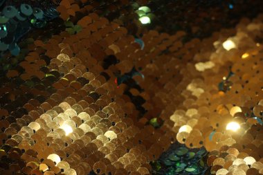 Çok renkli parlak pullar. Arkaplan olarak pullu kumaş. Parıltılı dokular mevsimin modası. Parlak holografik mavi, altın rengi.