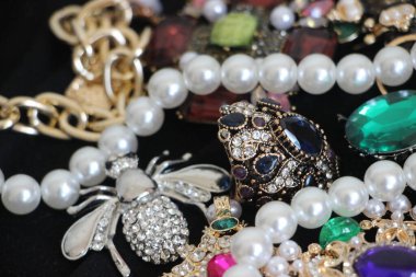 Zümrüt değerli taşlı klasik broşürler. Farklı renklerde cam ve metal broşlar. Renkli ve moda broşları. Lüks bir geçmişi var. Seçici odak