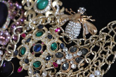 Zümrüt değerli taşlı klasik broşürler. Farklı renklerde cam ve metal broşlar. Renkli ve moda broşları. Lüks bir geçmişi var. Seçici odak