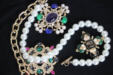 Zümrüt değerli taşlı klasik broşürler. Farklı renklerde cam ve metal broşlar. Renkli ve moda broşları. Lüks bir geçmişi var. Seçici odak