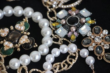 Zümrüt değerli taşlı klasik broşürler. Farklı renklerde cam ve metal broşlar. Renkli ve moda broşları. Lüks bir geçmişi var. Seçici odak