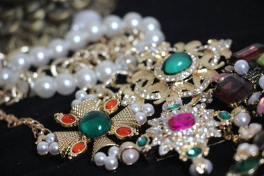 Zümrüt değerli taşlı klasik broşürler. Farklı renklerde cam ve metal broşlar. Renkli ve moda broşları. Lüks bir geçmişi var. Seçici odak