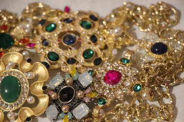 Zümrüt değerli taşlı klasik broşürler. Farklı renklerde cam ve metal broşlar. Renkli ve moda broşları. Lüks bir geçmişi var. Seçici odak