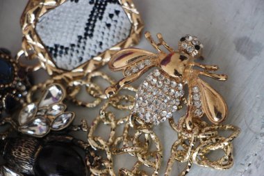 Zümrüt değerli taşlı klasik broşürler. Farklı renklerde cam ve metal broşlar. Renkli ve moda broşları. Lüks bir geçmişi var. Seçici odak