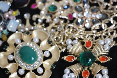 Zümrüt değerli taşlı klasik broşürler. Farklı renklerde cam ve metal broşlar. Renkli ve moda broşları. Lüks bir geçmişi var. Seçici odak