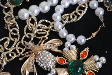 Zümrüt değerli taşlı klasik broşürler. Farklı renklerde cam ve metal broşlar. Renkli ve moda broşları. Lüks bir geçmişi var. Seçici odak