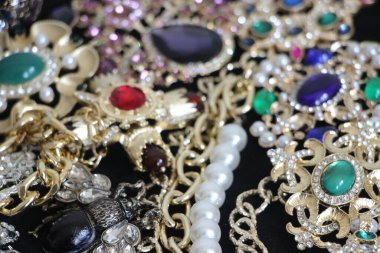 Zümrüt değerli taşlı klasik broşürler. Farklı renklerde cam ve metal broşlar. Renkli ve moda broşları. Lüks bir geçmişi var. Seçici odak