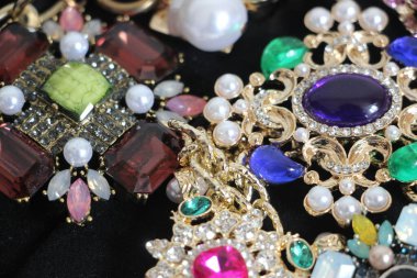 Zümrüt değerli taşlı klasik broşürler. Farklı renklerde cam ve metal broşlar. Renkli ve moda broşları. Lüks bir geçmişi var. Seçici odak