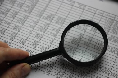 İş analisti finansal raporu incelemek için büyütme kullanıyor. Yatırım ve iş analitik büyümesinin geri dönüşünü analiz etme kavramı.