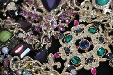 Zümrüt değerli taşlı klasik broşürler. Farklı renklerde cam ve metal broşlar. Renkli ve moda broşları. Lüks bir geçmişi var. Seçici odak