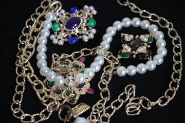 Zümrüt değerli taşlı klasik broşürler. Farklı renklerde cam ve metal broşlar. Renkli ve moda broşları. Lüks bir geçmişi var. Seçici odak