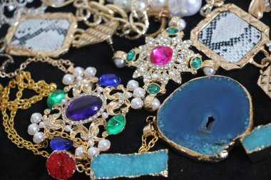 Zümrüt değerli taşlı klasik broşürler. Farklı renklerde cam ve metal broşlar. Renkli ve moda broşları. Lüks bir geçmişi var. Seçici odak