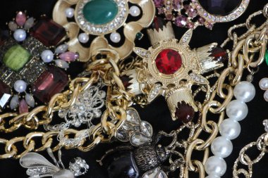 Zümrüt değerli taşlı klasik broşürler. Farklı renklerde cam ve metal broşlar. Renkli ve moda broşları. Lüks bir geçmişi var. Seçici odak