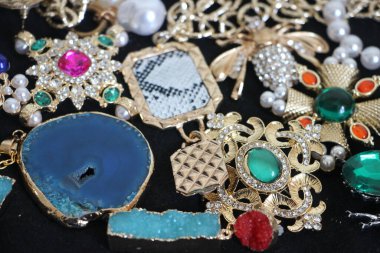 Zümrüt değerli taşlı klasik broşürler. Farklı renklerde cam ve metal broşlar. Renkli ve moda broşları. Lüks bir geçmişi var. Seçici odak