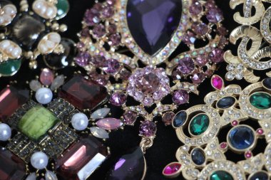 Zümrüt değerli taşlı klasik broşürler. Farklı renklerde cam ve metal broşlar. Renkli ve moda broşları. Lüks bir geçmişi var. Seçici odak