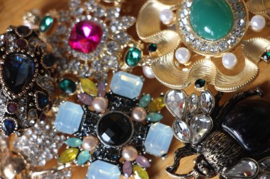 Zümrüt değerli taşlı klasik broşürler. Farklı renklerde cam ve metal broşlar. Renkli ve moda broşları. Lüks bir geçmişi var. Seçici odak