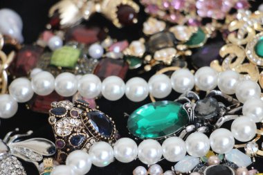 Zümrüt değerli taşlı klasik broşürler. Farklı renklerde cam ve metal broşlar. Renkli ve moda broşları. Lüks bir geçmişi var. Seçici odak