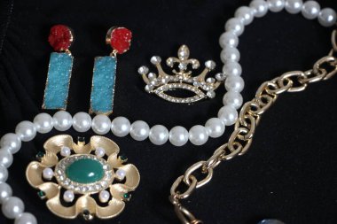 Zümrüt değerli taşlı klasik broşürler. Farklı renklerde cam ve metal broşlar. Renkli ve moda broşları. Lüks bir geçmişi var. Seçici odak