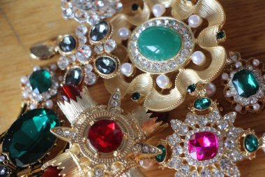 Zümrüt değerli taşlı klasik broşürler. Farklı renklerde cam ve metal broşlar. Renkli ve moda broşları. Lüks bir geçmişi var. Seçici odak