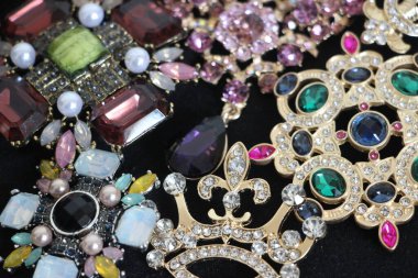 Zümrüt değerli taşlı klasik broşürler. Farklı renklerde cam ve metal broşlar. Renkli ve moda broşları. Lüks bir geçmişi var. Seçici odak