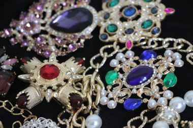 Zümrüt değerli taşlı klasik broşürler. Farklı renklerde cam ve metal broşlar. Renkli ve moda broşları. Lüks bir geçmişi var. Seçici odak