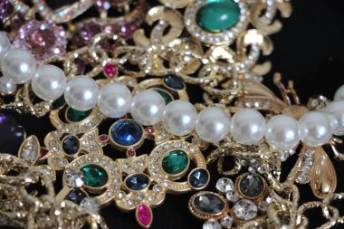 Zümrüt değerli taşlı klasik broşürler. Farklı renklerde cam ve metal broşlar. Renkli ve moda broşları. Lüks bir geçmişi var. Seçici odak