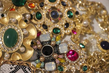 Zümrüt değerli taşlı klasik broşürler. Farklı renklerde cam ve metal broşlar. Renkli ve moda broşları. Lüks bir geçmişi var. Seçici odak