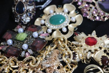 Zümrüt değerli taşlı klasik broşürler. Farklı renklerde cam ve metal broşlar. Renkli ve moda broşları. Lüks bir geçmişi var. Seçici odak