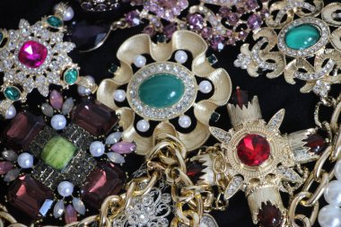 Zümrüt değerli taşlı klasik broşürler. Farklı renklerde cam ve metal broşlar. Renkli ve moda broşları. Lüks bir geçmişi var. Seçici odak