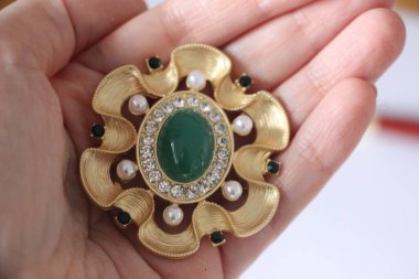 Zümrüt değerli taşlı klasik broşürler. Farklı renklerde cam ve metal broşlar. Renkli ve moda broşları. Lüks bir geçmişi var. Seçici odak