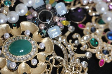 Zümrüt değerli taşlı klasik broşürler. Farklı renklerde cam ve metal broşlar. Renkli ve moda broşları. Lüks bir geçmişi var. Seçici odak