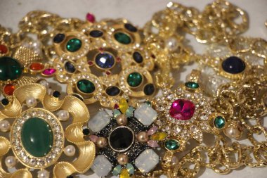 Zümrüt değerli taşlı klasik broşürler. Farklı renklerde cam ve metal broşlar. Renkli ve moda broşları. Lüks bir geçmişi var. Seçici odak