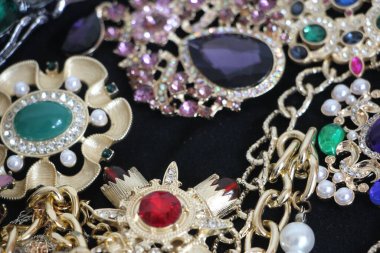 Zümrüt değerli taşlı klasik broşürler. Farklı renklerde cam ve metal broşlar. Renkli ve moda broşları. Lüks bir geçmişi var. Seçici odak