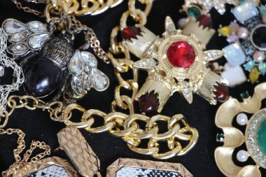 Zümrüt değerli taşlı klasik broşürler. Farklı renklerde cam ve metal broşlar. Renkli ve moda broşları. Lüks bir geçmişi var. Seçici odak