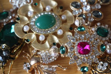 Zümrüt değerli taşlı klasik broşürler. Farklı renklerde cam ve metal broşlar. Renkli ve moda broşları. Lüks bir geçmişi var. Seçici odak