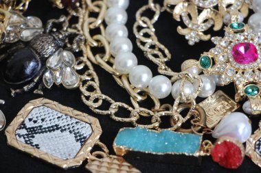 Zümrüt değerli taşlı klasik broşürler. Farklı renklerde cam ve metal broşlar. Renkli ve moda broşları. Lüks bir geçmişi var. Seçici odak