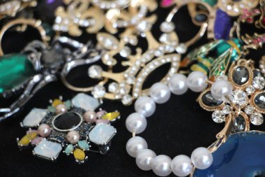 Zümrüt değerli taşlı klasik broşürler. Farklı renklerde cam ve metal broşlar. Renkli ve moda broşları. Lüks bir geçmişi var. Seçici odak