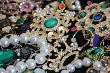 Zümrüt değerli taşlı klasik broşürler. Farklı renklerde cam ve metal broşlar. Renkli ve moda broşları. Lüks bir geçmişi var. Seçici odak