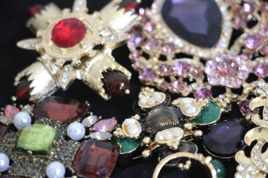 Zümrüt değerli taşlı klasik broşürler. Farklı renklerde cam ve metal broşlar. Renkli ve moda broşları. Lüks bir geçmişi var. Seçici odak