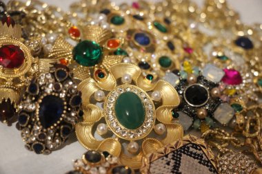 Zümrüt değerli taşlı klasik broşürler. Farklı renklerde cam ve metal broşlar. Renkli ve moda broşları. Lüks bir geçmişi var. Seçici odak