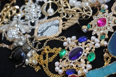 Zümrüt değerli taşlı klasik broşürler. Farklı renklerde cam ve metal broşlar. Renkli ve moda broşları. Lüks bir geçmişi var. Seçici odak